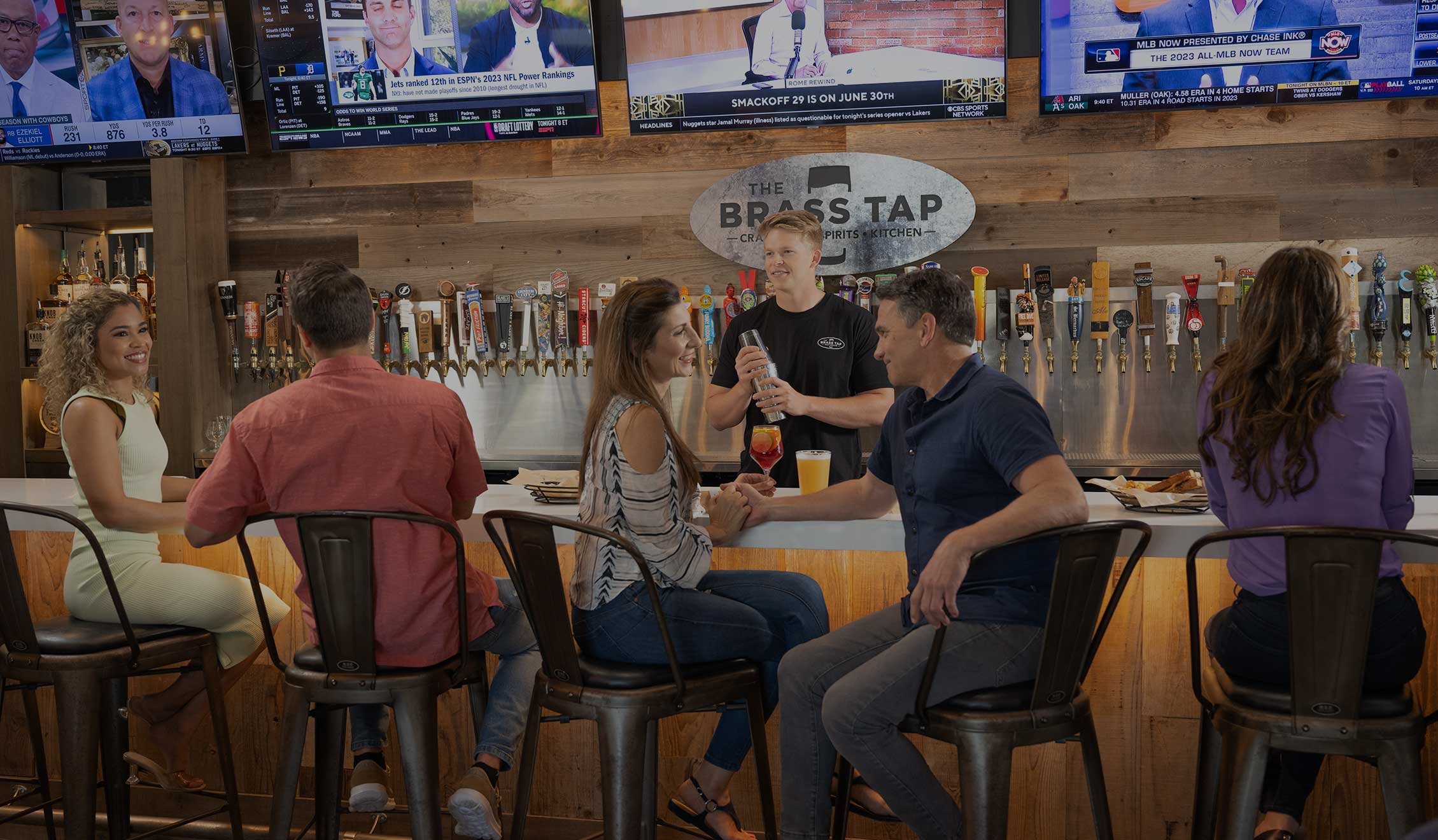 People sitting at a bar. The Brass Tap offers a huge selection of craft beers.