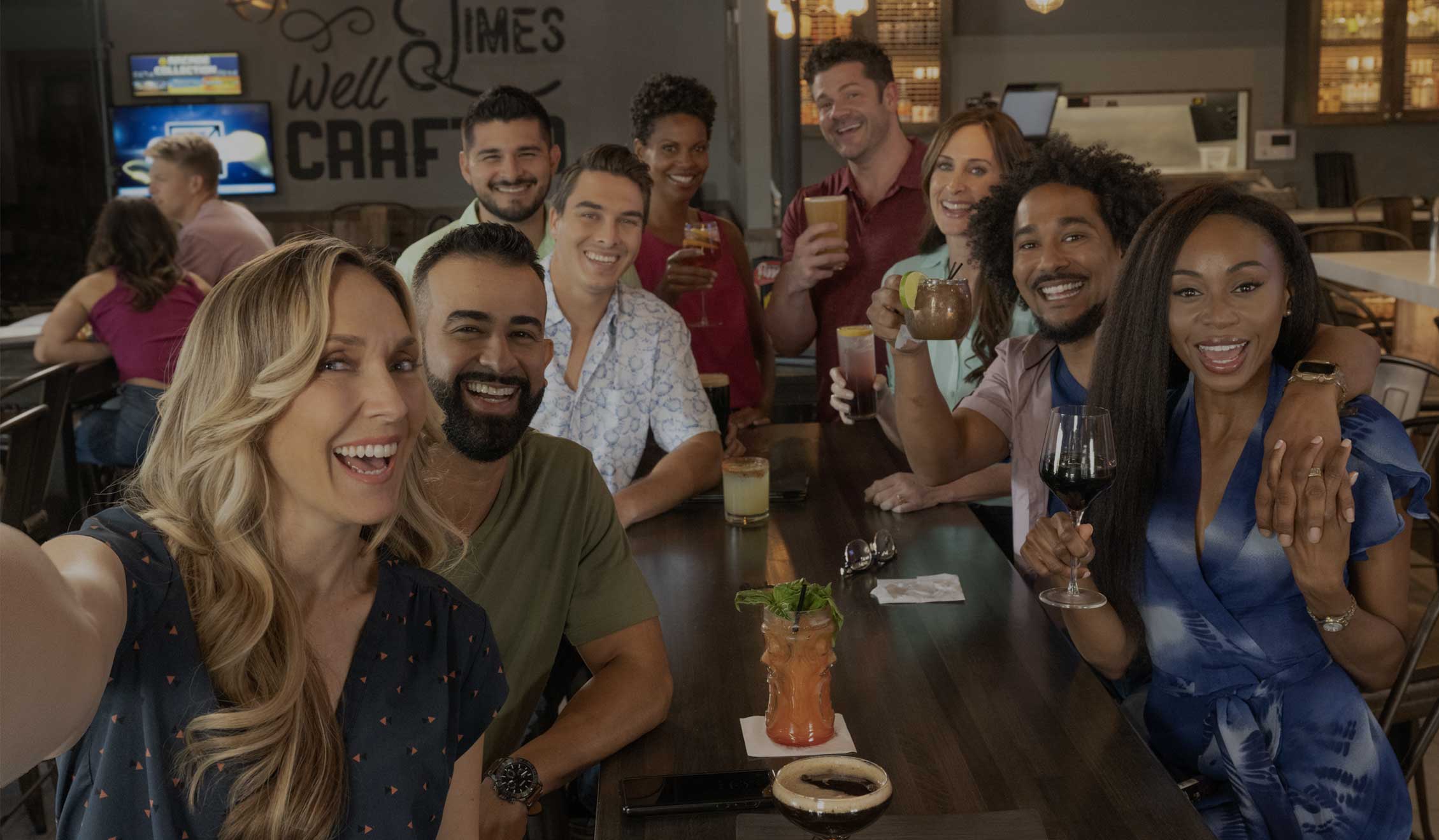 A group of friends taking a selfie at an upscale beer bar. The Brass Tap has hundreds of taps, including specialty and local beers.